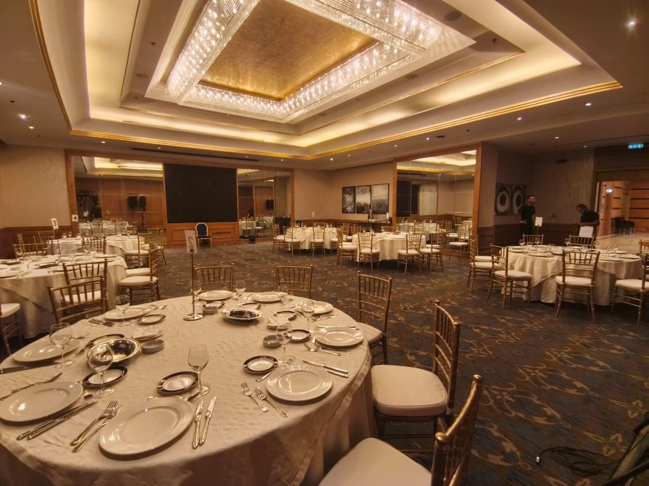 Ballroom reception with round tables and gold chiavari chairs